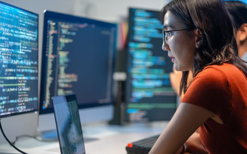 Écrans de code dans une salle informatique